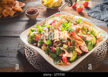 Cucina araba; l'insalata più famosa del Libano 'Fattoush'. È un succulento mix croccante di cetriolo, pomodori, ravanello, pane pita tostato e menta fresca. Foto Stock