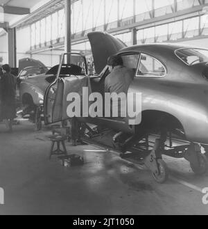 Storia Porsche. Una rara vista della fabbrica di automobili Porsche a Stoccarda in Germania negli anni '1950s. Nella costruzione della fabbrica Porsche automobili è visto in diverse fasi di produzione su una linea di assemblaggio dove gli operai stanno installando e mettendo insieme le automobili Porsche. 1951. Foto Stock