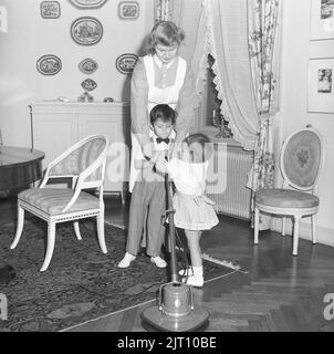 Cameriera negli anni '1940s. Una giovane donna che lavora in una casa come cameriera e con gli sguardi di essa anche la bambina, come permette loro di giocare e provare la macchina che è fatta per lucidare i pavimenti. Svezia 1947 Kristoffersson Ref X147-1 Foto Stock