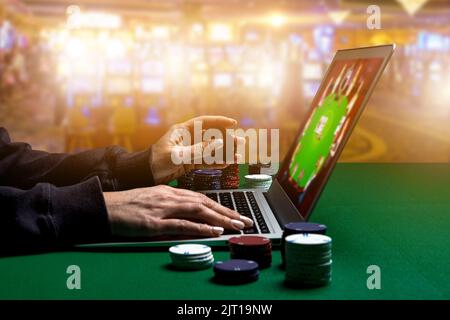 Donna mani con Gambling chip utilizzando un computer portatile per giocare al casinò online. Concetto di attività di svago virtuale. Foto Stock