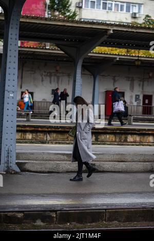 Turisti che tirano i bagagli. Pendolari a piedi alla stazione ferroviaria piattaforma a Bucarest, Romania, 2022 Foto Stock