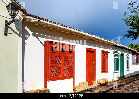 Strada con antiche case in stile coloniale con porte e finestre colorate nella storica città di Tiradentes a Minas Gerais, Brasile Foto Stock