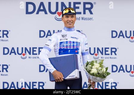 Oberried, Germania. 27th ago, 2022. Mauri Vansettant del Team Quickstep Alpha-Vinyl si alza sul podio nella zona finale dello Schauinsland durante la cerimonia di premiazione nella maglia bianca del miglior giovane pilota. La 3rd° tappa del Tour della Germania porta da Friburgo attraverso il Breisgau e la Terra di Markgräfler allo Schauinsland. Credit: Philip von Ditfurth/dpa/Alamy Live News Foto Stock