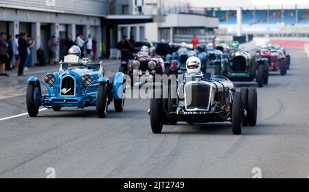 I concorrenti che si fanno strada in pista per la partenza della MRL Pre-War Sports Car 'BRDC 500' Race, al Silverstone Classic 2022 Foto Stock