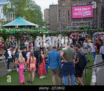 Centro di Edimburgo, Scozia, Regno Unito. 27th ago, 2022. Affollato fine settimana dell'Edinburgh Festival Fringe, temperatura di 18 gradi, ammira le strade affollate da persone di ogni tipo godendo dell'atmosfera vibrante. Foto: Persone che si divertiscono a incontrarsi a Undetbelly Bristo Square. Credit: Arch White/Alamy Live News Foto Stock