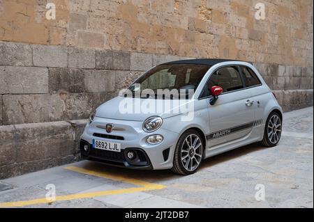 Un piccolo bianco moderno Fiat 500 Abarth parcheggiato in una strada vicino ad un muro Foto Stock