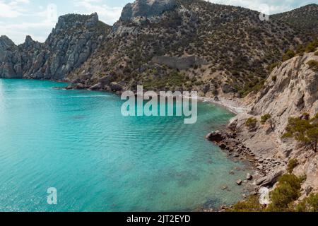 Costa rocciosa con mare bello e onde azzurre. Foto Stock
