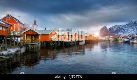 Bellissimo rorbu arancione al tramonto. Villaggio di pescatori Foto Stock