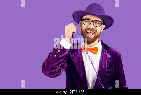 Un uomo sorridente parla sul telefono fisso Foto Stock