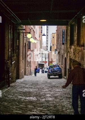 Seattle USA - Luglio 20 2008; zona storica di Post Alley poco illuminata in città. Con luci gialle, strade acciottolate e cartelli al neon Foto Stock