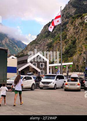 Kazbegi, Georgia - 07 23 2022: Bandiera georgiana bianco-rossa che sventola sopra Lars Checkpoint aka confine punto di attraversamento Dariali a Mtskheta-Stepantsminda-Larsi Foto Stock