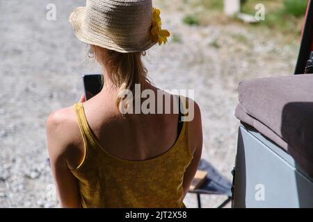 Donna in vacanza con il furgone, che chiacchiera sul suo smartphone. Foto Stock