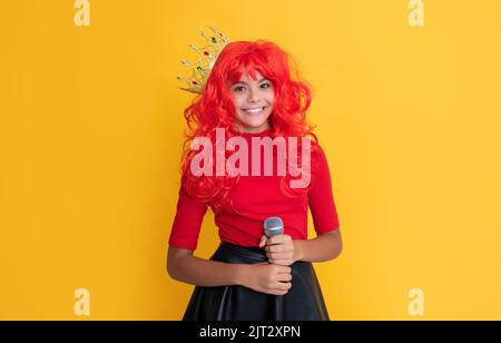 bambino sorriso in corona con microfono su sfondo giallo Foto Stock