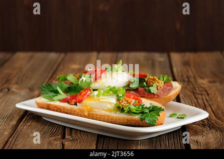 Sandwich all'uovo in camicia con peperoncino, scalogno e salame con sfondo spaziale Foto Stock