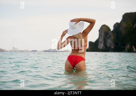 Ho perso il mio cuore al mare. Ripresa retroversa di una giovane donna in posa con il bikini in acqua. Foto Stock