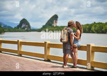 Baci in paradiso: Una coppia affettuosa che condivide un bacio mentre è in vacanza. Foto Stock