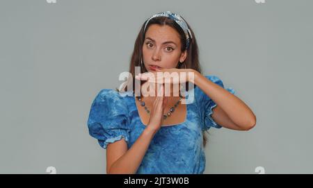 Time out, hai bisogno di una pausa. Stanco grave rovesciato bella giovane donna in vestito mostrando pausa relax gesto, limite o stop segno. Ragazza donna elegante adulto isolato da solo su sfondo grigio studio al coperto Foto Stock