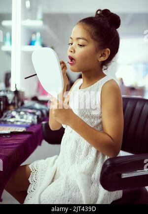 Carino doesnt succedono appena da sè. Una bambina cute che gioca con trucco in una stanza di vestirsi. Foto Stock