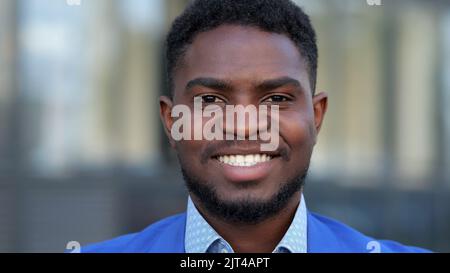 L'uomo d'affari nero ama l'occupazione mostrando un sorriso toothy Foto Stock