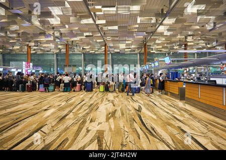 SINGAPORE - CIRCA GENNAIO 2020: Le persone sono in fila in attesa del check-in all'aeroporto Changi di Singapore. Foto Stock