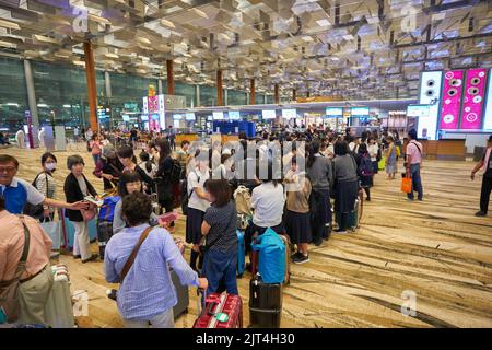 SINGAPORE - CIRCA GENNAIO 2020: Le persone sono in fila in attesa del check-in all'aeroporto Changi di Singapore. Foto Stock