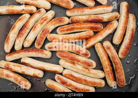 nella padella ci sono un sacco di deliziose salsicce fritte Foto Stock