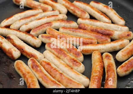 nella padella ci sono un sacco di deliziose salsicce fritte Foto Stock