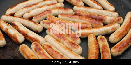 nella padella ci sono un sacco di deliziose salsicce fritte Foto Stock