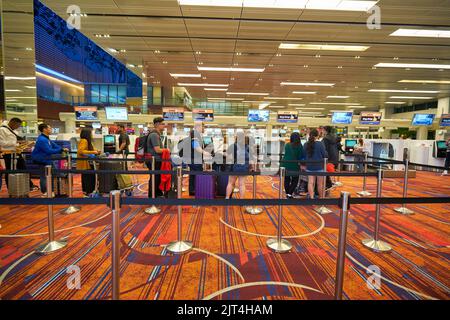 SINGAPORE - CIRCA GENNAIO 2020: Le persone sono in fila in attesa del check-in all'aeroporto Changi di Singapore. Foto Stock