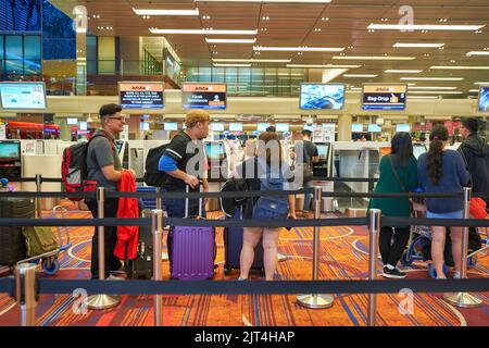 SINGAPORE - CIRCA GENNAIO 2020: Le persone sono in fila in attesa del check-in all'aeroporto Changi di Singapore. Foto Stock