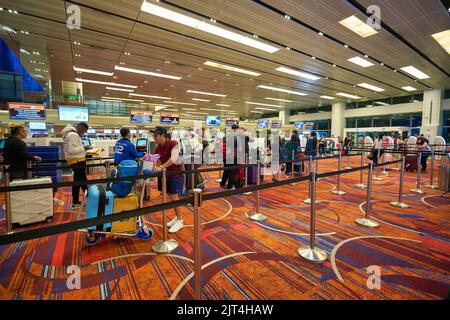 SINGAPORE - CIRCA GENNAIO 2020: Le persone sono in fila in attesa del check-in all'aeroporto Changi di Singapore. Foto Stock