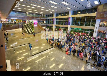 SINGAPORE - CIRCA GENNAIO 2020: Vista dall'alto della folla di persone in attesa in coda all'arrivo nella Sala immigrazione nell'Aeroporto Internazionale Changi di Singapore. Foto Stock