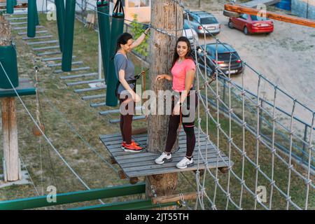 Due migliori amici si allenano sui corsi nel parco avventura Foto Stock