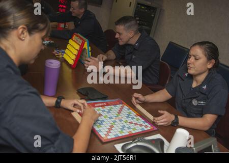 U.S. Navy Cryptologic Technician (Technical) 2nd Class Right, assegnato al Carrier Strike Group 1, gioca a un gioco da tavolo a settembre 140928 Foto Stock