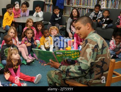 US Navy Utilitiesman Constructionman Jordan Delasalas, primo piano, un Seabee assegnato alla Naval Mobile Construction Battaglione 74, legge ai bambini presso la biblioteca della Naval Station Rota, Spagna, 30 marzo 2011 110330 Foto Stock