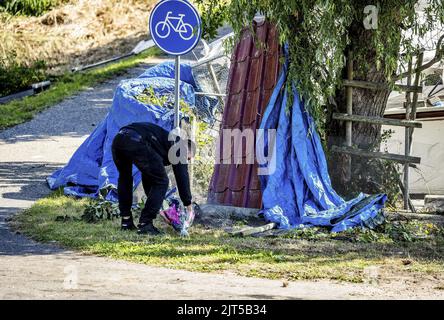 2022-08-28 11:53:24:19 NIEUW BEIJERLAND - Un residente locale mette i fiori sulla scena dell'incidente in cui un camion ha guidato da un argine a coloro che partecipano a una festa di quartiere il Sabato sera. Sei persone sono state uccise in questo. Sette feriti sono stati ricoverati in ospedale. ANP JEFFREY GROENEWEG olanda fuori - belgio fuori Foto Stock