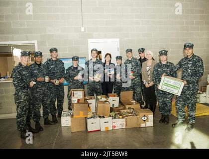 I marinai degli Stati Uniti assegnati alla portaerei USS Abraham Lincoln (CVN 72) posano per una foto con una parte degli articoli alimentari che hanno donato alla Virginia Peninsula Food Bank il 25 novembre 2013, a Newport News, va 131125 Foto Stock