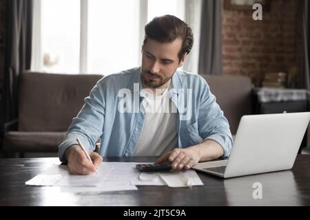 Un uomo serio e bello dell'utente del computer che fa il lavoro di contabilità Foto Stock