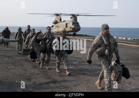 Soldati statunitensi assegnati al 3rd General Support Aviation Battalion, 2nd Combat Aviation Brigade, 2nd divisione fanteria sbarcano da un elicottero dell'esercito CH-47F Chinook sul ponte di volo dell'anfibio 140411 Foto Stock