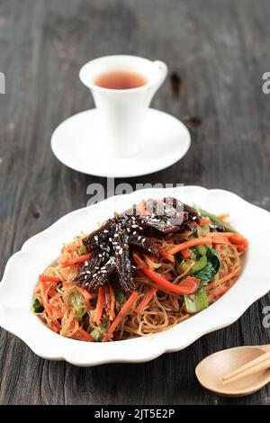 Japchae Coreano Stir Fried Vermicelli con Bulgogi di verdure e manzo. Servito con tè Foto Stock