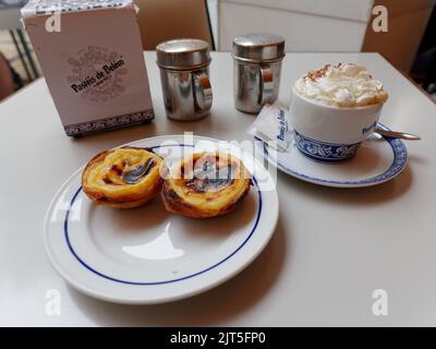 Pastel de Belem (Crostate alla crema) e caffè su un tavolo nel famoso negozio Pasteis de Belem nel quartiere Belem di Lisbona, Portogallo. Foto Stock