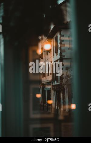 Un inquadramento verticale ad angolo basso di un edificio a Saint Jean De Luz di notte visto da un bar Foto Stock