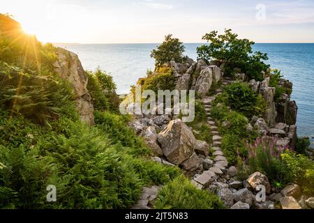 sole splendente al Røverborgen sulla costa del mar baltico a bornholm danimarca Foto Stock