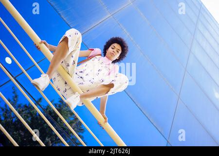 Seria donna nera seduta su ringhiera Foto Stock