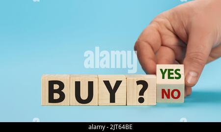 È il momento di acquistare. La mano gira un cubo e cambia le parole compra no per comprare sì. Concetto aziendale. Spazio di copia. Foto Stock