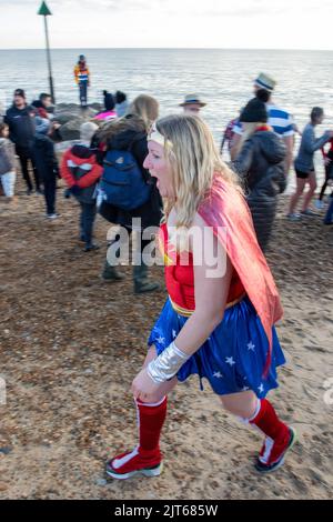 Il giorno di Natale tuffarsi a Felixstowe quando in sostegno della carità St Elizabeth Hospice persone molti in abito di fantasia pagaia o nuotare nel Mare del Nord Foto Stock