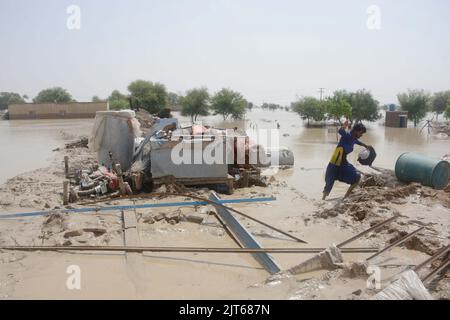 (220828) -- RAJANPUR, 28 agosto 2022 (Xinhua) -- Un uomo prende gli articoli utili da una casa alluvione-colpita nel distretto di Rajanpur della provincia del Punjab del Pakistan il 27 agosto 2022. Il numero di morti in incidenti separati causati da forti piogge in tutto il Pakistan è salito a 1.000 dall'inizio della stagione monsonica il 14 giugno, la National Disaster Management Authority (NDMA) ha detto il Sabato notte. (Foto di Mansoor/Xinhua) Foto Stock