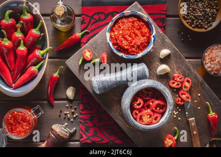 Cucina araba: Pasta di Harissa mediorientale deliziosa. Si compone di peperoncini piccanti, aglio e spezie. Vista dall'alto con primo piano. Foto Stock
