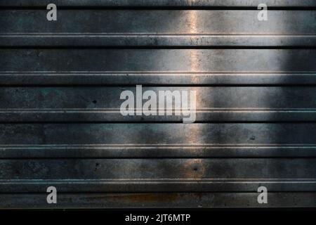 Un vecchio foglio di ferro ondulato sporco e arrugginito sfondo industriale la trama di una recinzione di alluminio stropicciata Foto Stock