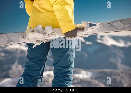 Foto ravvicinata dello sciatore femminile con lo sci in mano. Concetto di sport invernali Foto Stock